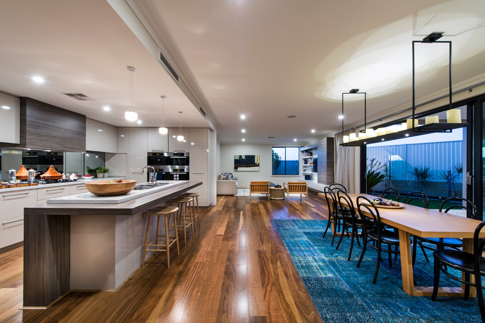 Design ideas for a contemporary open plan kitchen in Perth with flat-panel cabinets, white cabinets, medium hardwood floors and with island.