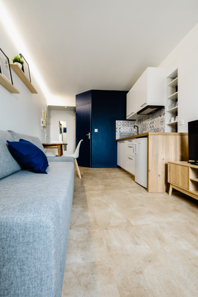 Foto de salón actual pequeño con paredes azules, suelo de travertino, televisor independiente y suelo beige