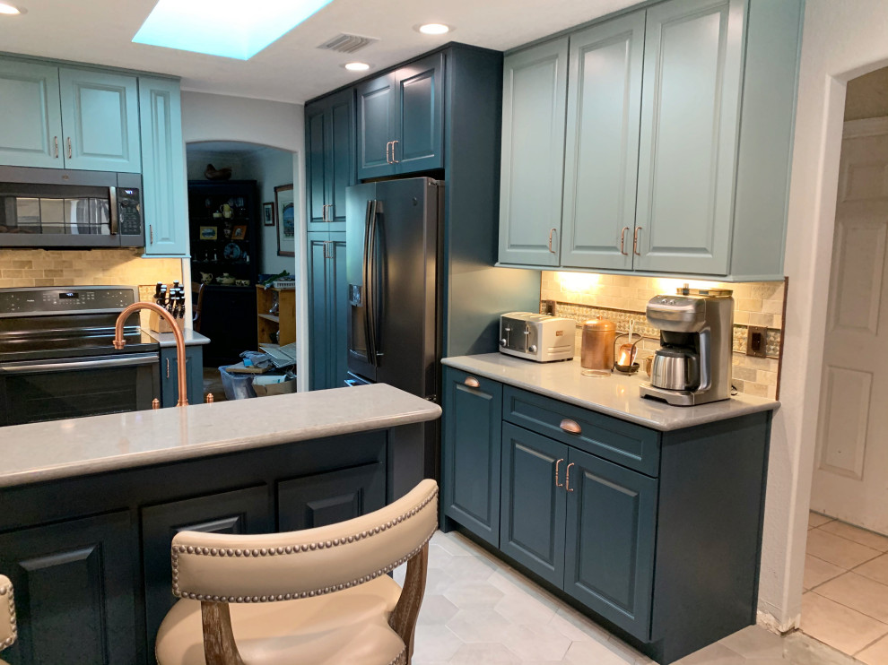 Photo of a mid-sized u-shaped eat-in kitchen in Orlando with an undermount sink, raised-panel cabinets, blue cabinets, quartz benchtops, brown splashback, brick splashback, black appliances, ceramic floors, a peninsula, grey floor, grey benchtop and recessed.