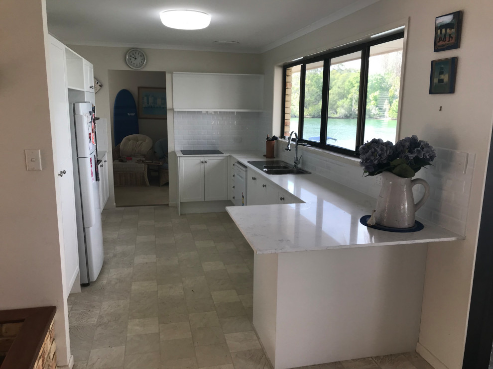 Design ideas for a mid-sized kitchen in Brisbane with shaker cabinets, white cabinets, quartz benchtops, white splashback and brick splashback.