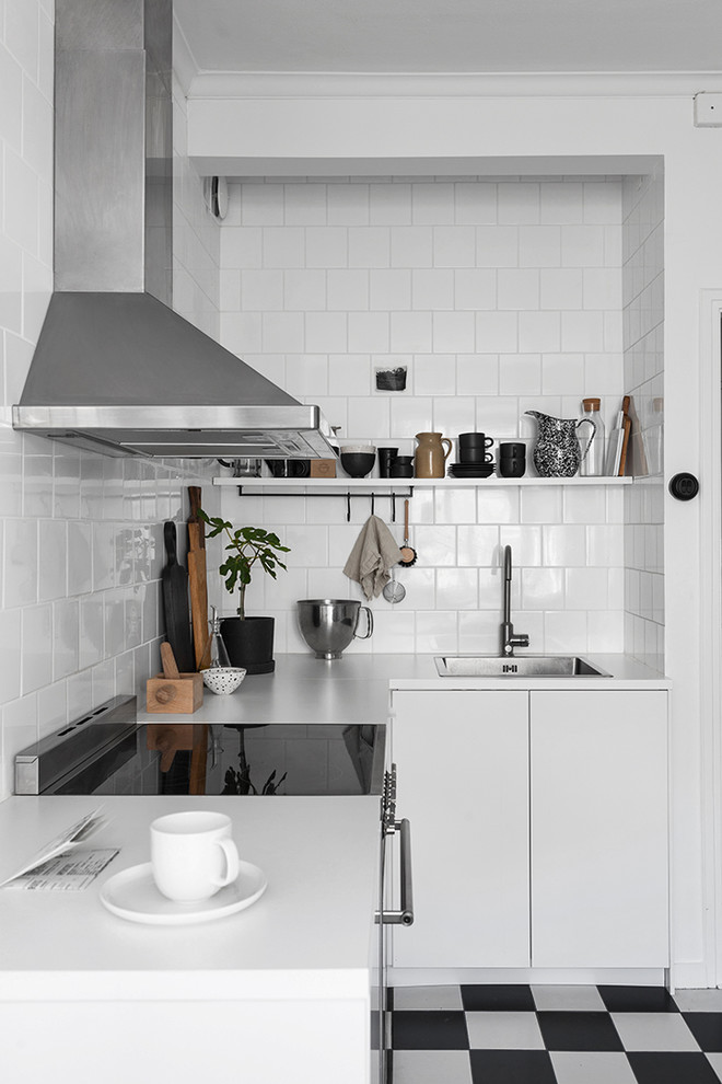 Design ideas for a small scandinavian l-shaped separate kitchen in Gothenburg with a single-bowl sink, flat-panel cabinets, white cabinets, laminate benchtops, white splashback, porcelain splashback, stainless steel appliances, ceramic floors and no island.