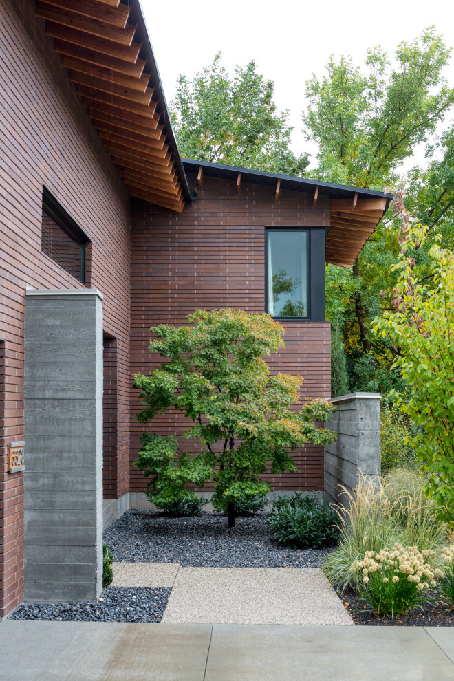 This is an example of a medium sized and brown contemporary split-level brick detached house in Salt Lake City with a pitched roof, a shingle roof and a brown roof.