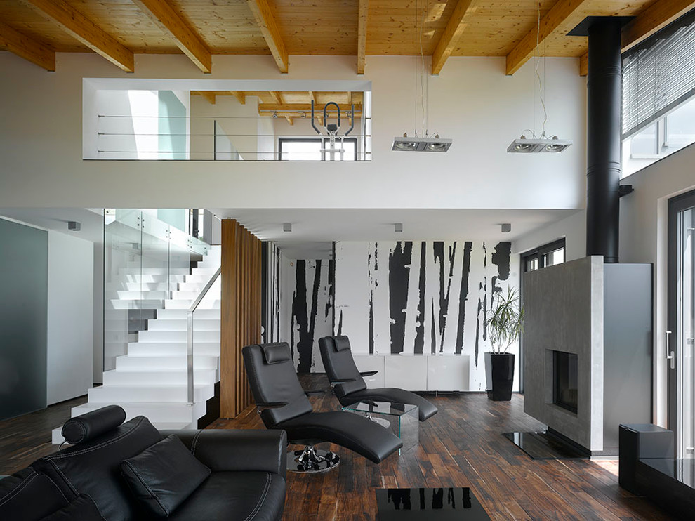 This is an example of an industrial open concept living room in Other with multi-coloured walls and dark hardwood floors.