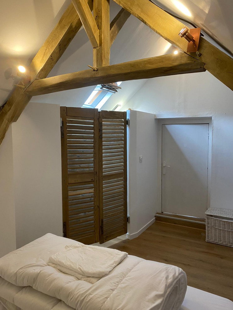Small scandi guest bedroom in Toulouse with blue walls, light hardwood flooring and exposed beams.