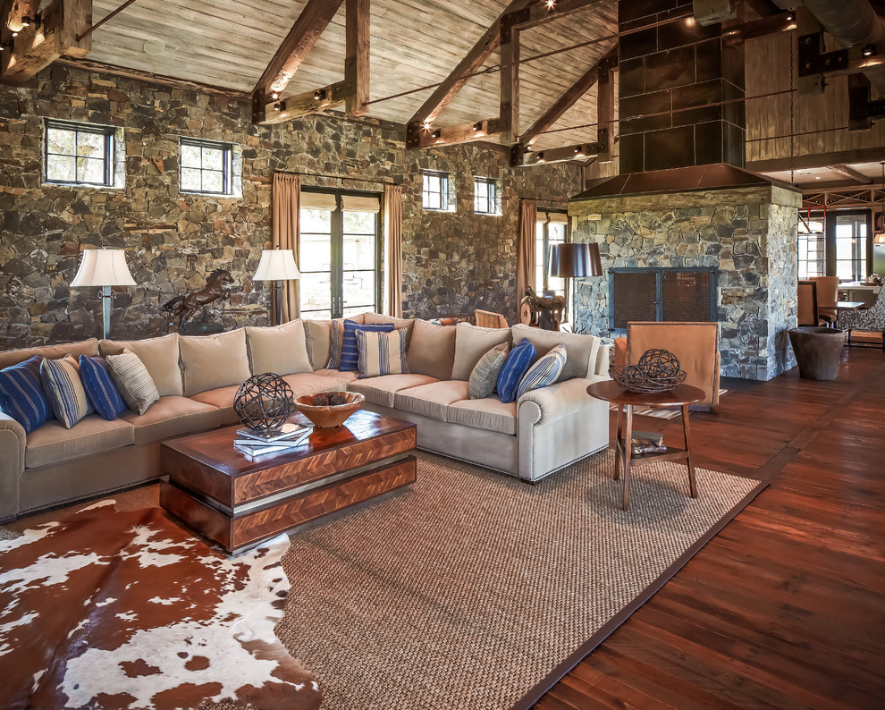Country open concept family room in Houston with dark hardwood floors, a standard fireplace and a stone fireplace surround.