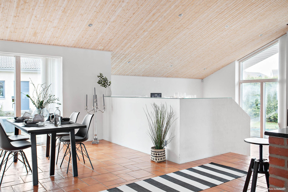 Photo of a contemporary dining room in Malmo with white walls and terra-cotta floors.