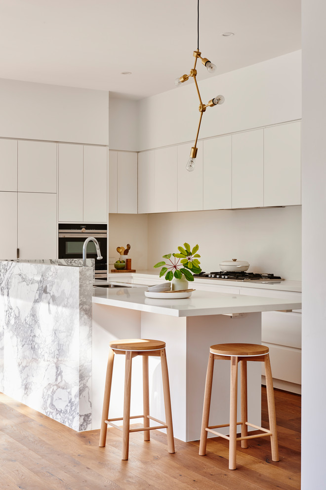 This is an example of a contemporary separate kitchen in Geelong with recessed-panel cabinets, white cabinets, marble benchtops, white splashback, with island and yellow benchtop.