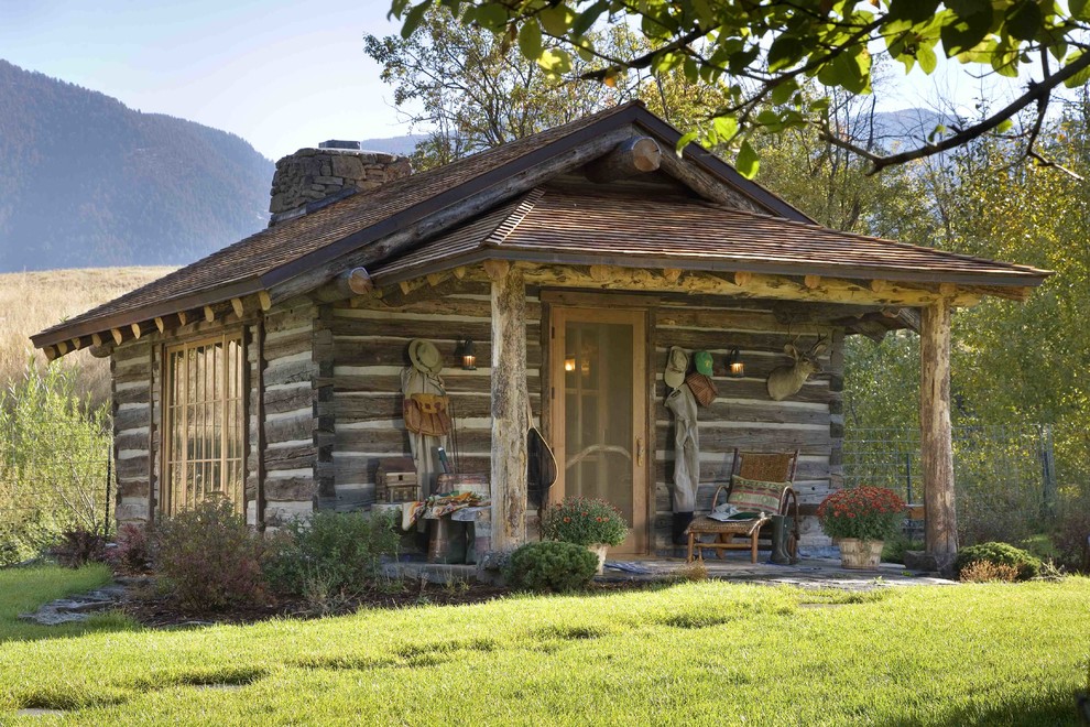Photo of a country exterior in Other with wood siding and a shingle roof.