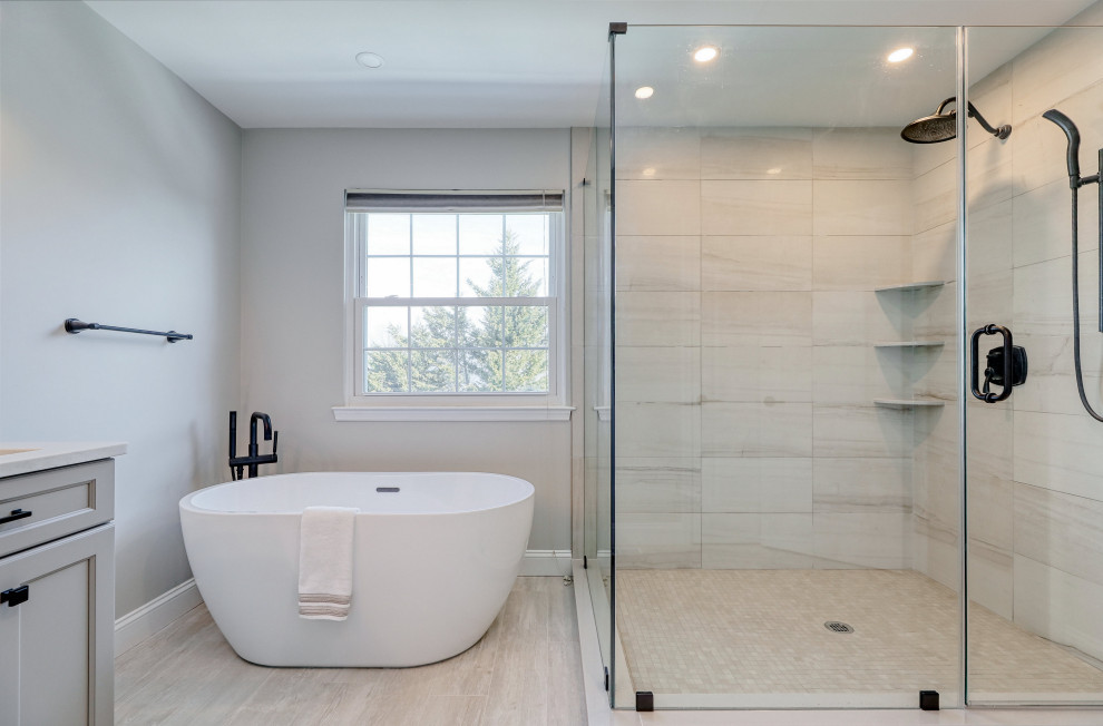 Inspiration for a large contemporary ensuite bathroom in Philadelphia with flat-panel cabinets, grey cabinets, a freestanding bath, a corner shower, grey walls, porcelain flooring, a submerged sink, engineered stone worktops, grey floors, white worktops, double sinks and a built in vanity unit.