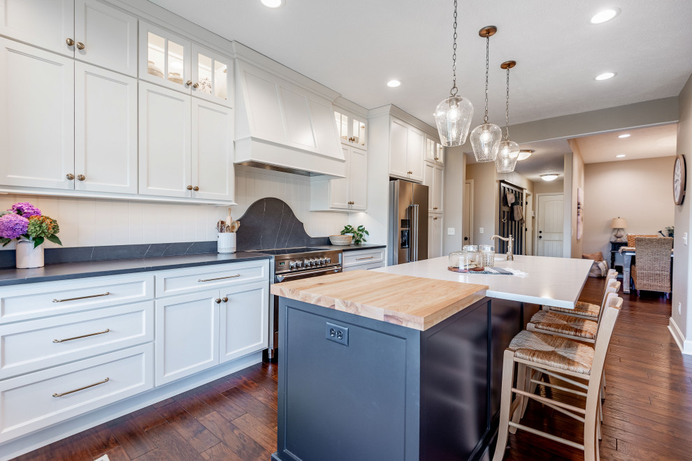 Inspiration for a mid-sized transitional l-shaped dark wood floor eat-in kitchen remodel with recessed-panel cabinets, white cabinets, white backsplash, an island, black countertops, shiplap backsplash and stainless steel appliances