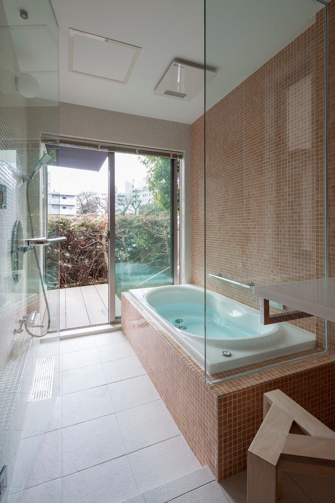 Photo of a contemporary bathroom in Tokyo with a hot tub, orange tile and multi-coloured walls.