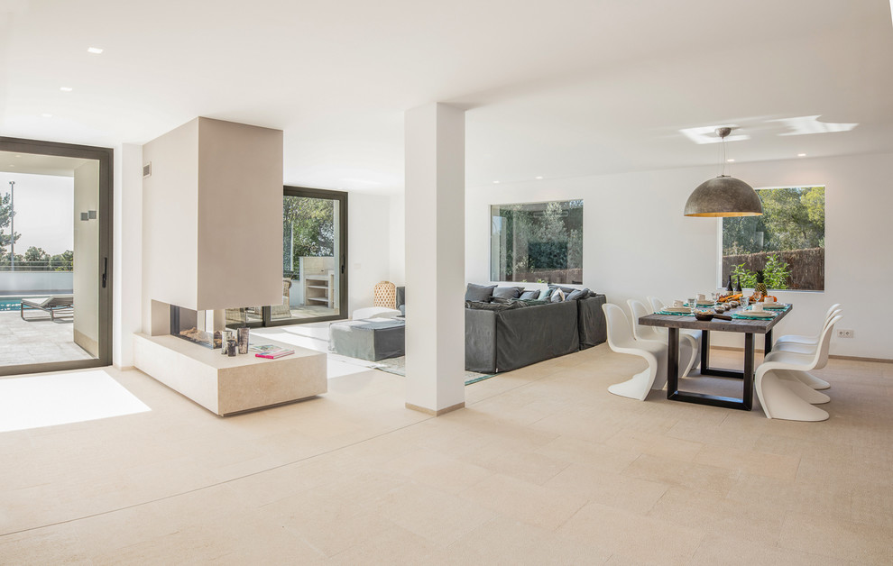 Large modern open concept living room in Palma de Mallorca with beige walls, marble floors, a standard fireplace, a concrete fireplace surround and a wall-mounted tv.