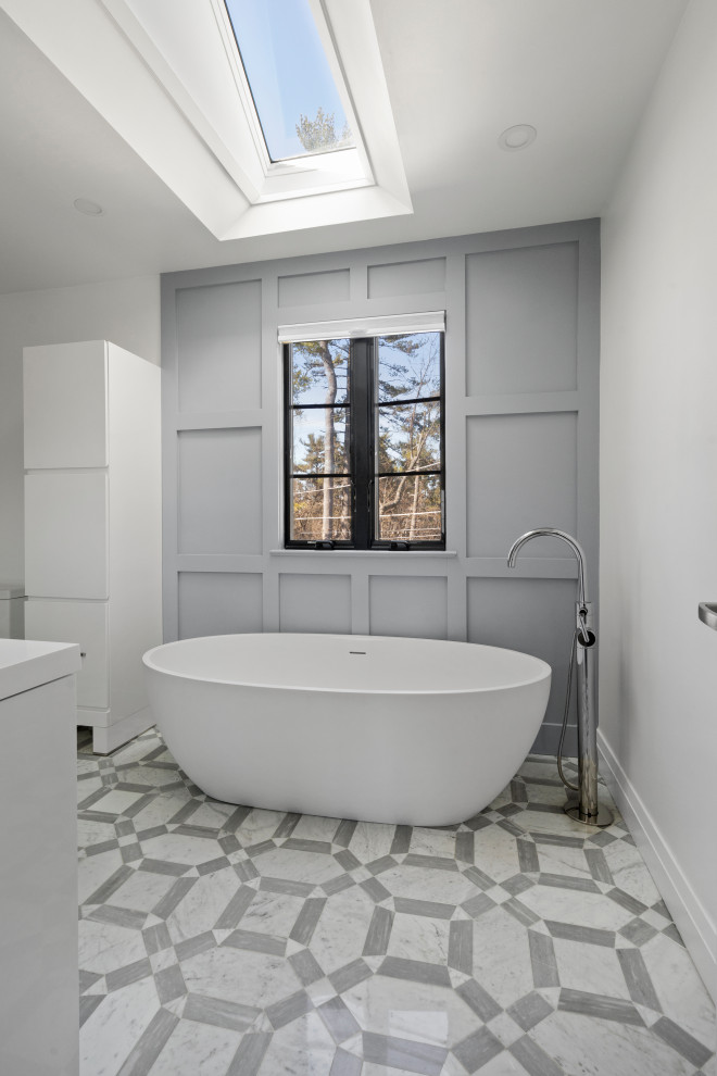 Photo of a mid-sized contemporary master bathroom with flat-panel cabinets, white cabinets, a freestanding tub, a curbless shower, gray tile, marble, white walls, marble floors, a console sink, grey floor, a hinged shower door, white benchtops and panelled walls.