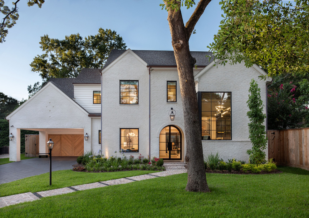 This is an example of an expansive contemporary two-storey white house exterior in Houston with mixed siding, a gable roof and a shingle roof.