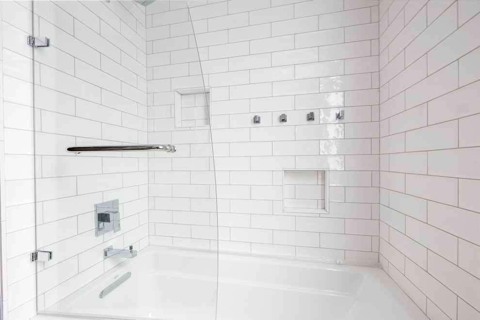 Mid-sized transitional white tile ceramic tile, white floor, single-sink and wainscoting alcove bathtub photo in Minneapolis with shaker cabinets, blue cabinets, a one-piece toilet, blue walls, an undermount sink, marble countertops, a hinged shower door and a freestanding vanity
