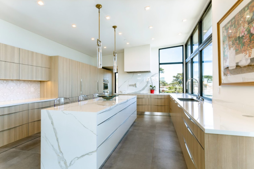 Large modern u-shaped eat-in kitchen in Los Angeles with an undermount sink, flat-panel cabinets, light wood cabinets, marble benchtops, white splashback, mosaic tile splashback, panelled appliances, ceramic floors, with island, grey floor and white benchtop.