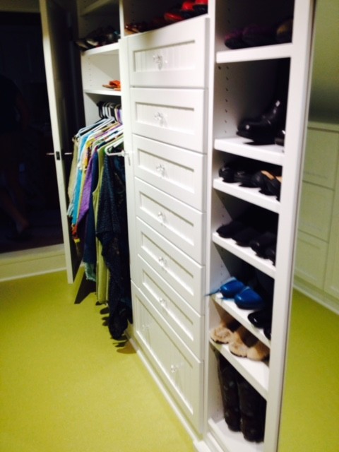 This is an example of a small eclectic gender-neutral walk-in wardrobe in Other with open cabinets, white cabinets and green floor.