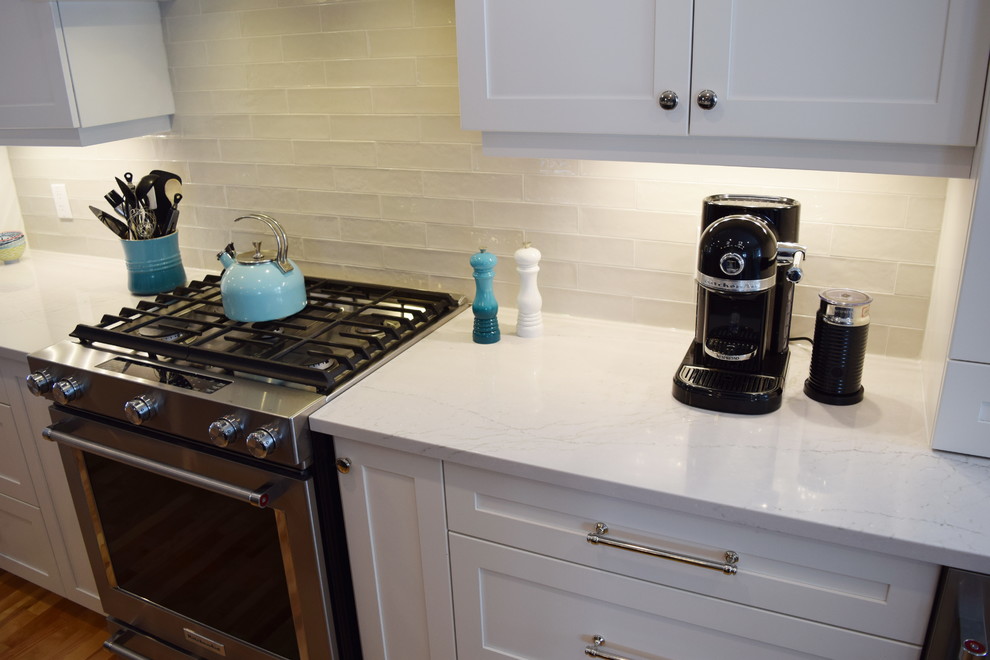Open concept kitchen - large transitional l-shaped light wood floor open concept kitchen idea in Ottawa with an undermount sink, shaker cabinets, white cabinets, quartz countertops, white backsplash, subway tile backsplash, stainless steel appliances and an island