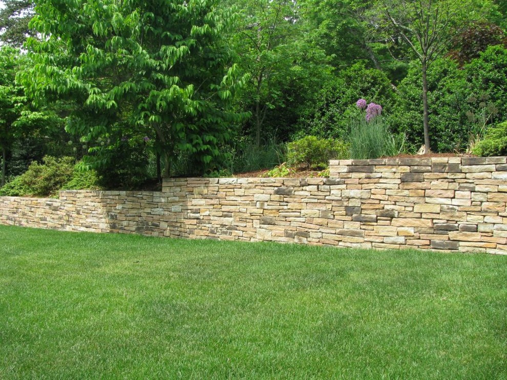 Large traditional backyard full sun garden in New York with a retaining wall.