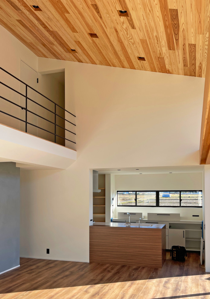 Стильный дизайн: открытая гостиная комната в стиле модернизм с серыми стенами, паркетным полом среднего тона, телевизором на стене, коричневым полом, деревянным потолком и обоями на стенах - последний тренд