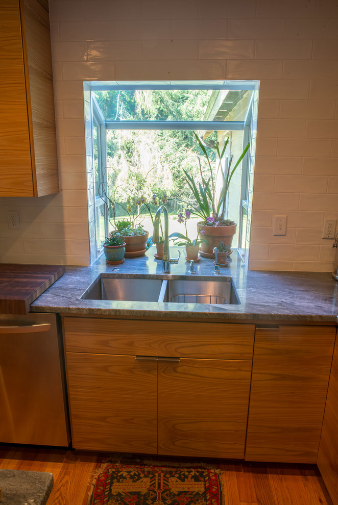 Eat-in kitchen - mid-sized transitional u-shaped medium tone wood floor eat-in kitchen idea with an undermount sink, flat-panel cabinets, medium tone wood cabinets, quartzite countertops, white backsplash, ceramic backsplash, stainless steel appliances and an island