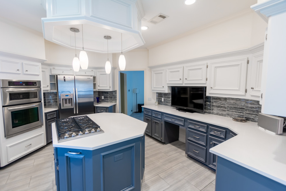 Enclosed kitchen - mid-sized transitional u-shaped ceramic tile and gray floor enclosed kitchen idea in Austin with a farmhouse sink, recessed-panel cabinets, white cabinets, quartzite countertops, blue backsplash, glass tile backsplash, stainless steel appliances, an island and white countertops