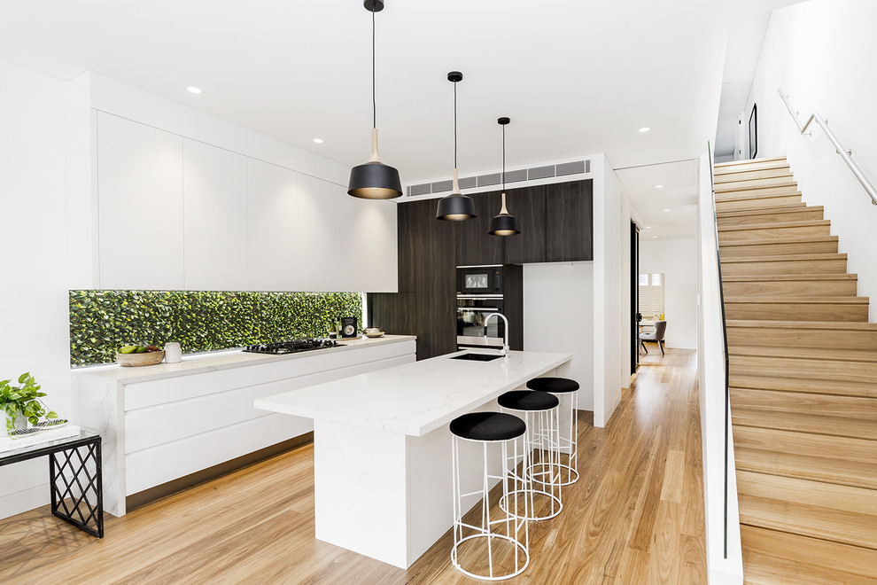 Inspiration for a contemporary kitchen in Sydney with a single-bowl sink, flat-panel cabinets, white cabinets, light hardwood floors, with island, beige floor and white benchtop.