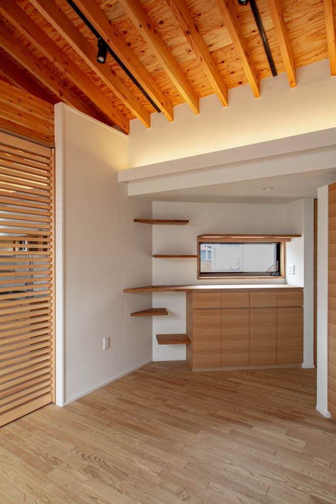 Diseño de sala de estar abierta escandinava de tamaño medio sin chimenea con paredes blancas, suelo de madera clara, televisor independiente, suelo beige y vigas vistas