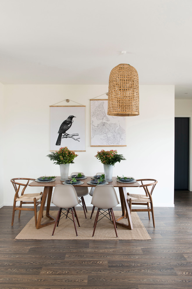 Inspiration for a beach style dining room in Auckland with dark hardwood floors, brown floor and white walls.