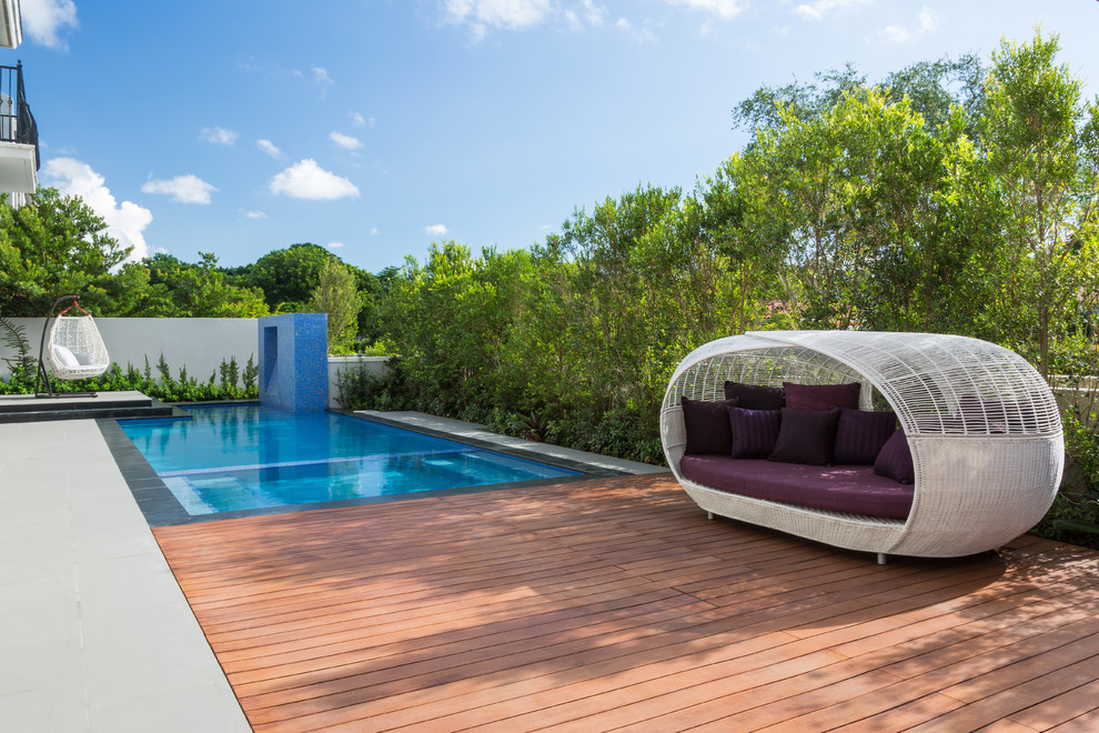 Inspiration for a mid-sized contemporary backyard rectangular lap pool in Miami with decking.