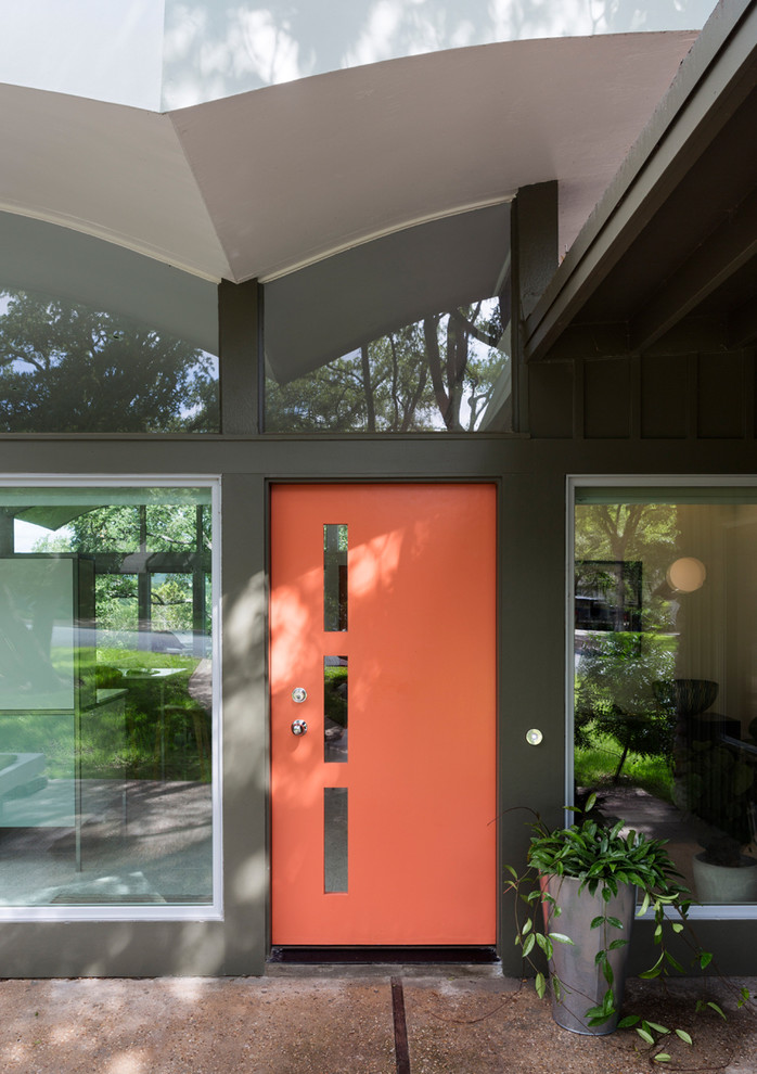 This is an example of a mid-sized midcentury front door in Austin with a single front door and a red front door.