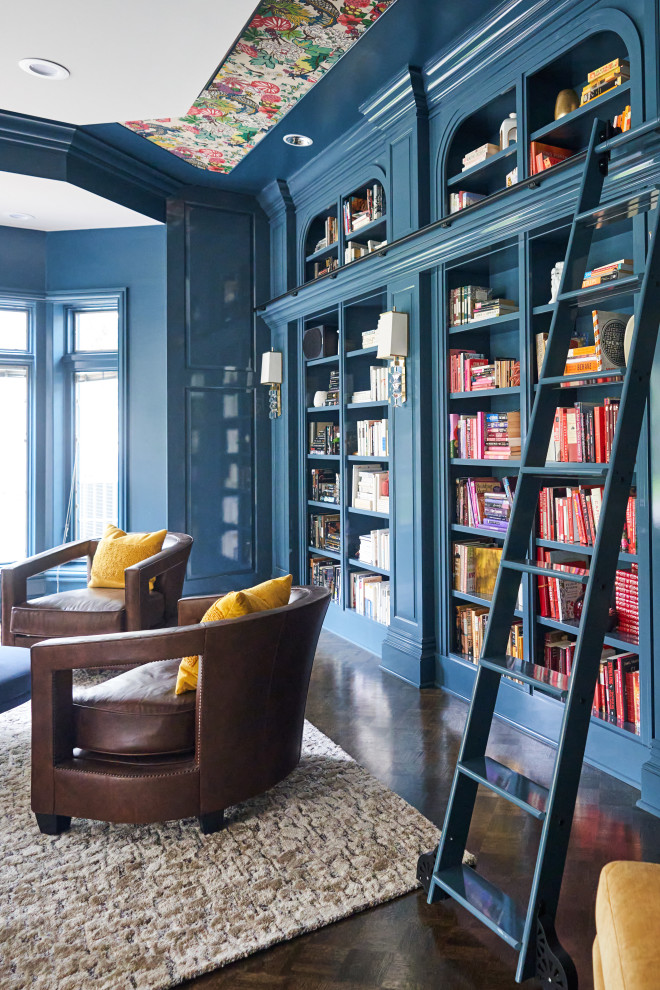 Bild på ett mellanstort vintage arbetsrum, med ett bibliotek, blå väggar, mörkt trägolv, en standard öppen spis, en spiselkrans i trä, ett fristående skrivbord och brunt golv