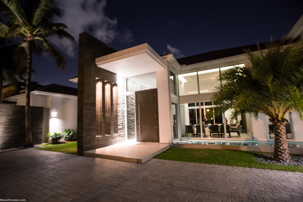Photo of a large contemporary entryway in Miami with grey walls and granite floors.