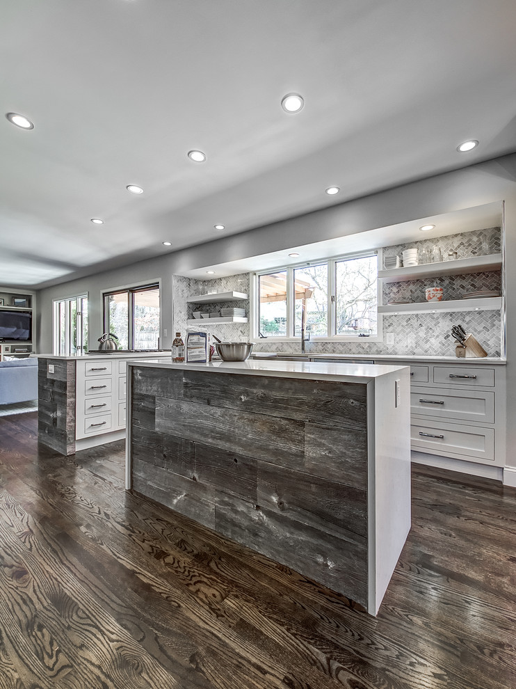 Kitchen - transitional dark wood floor kitchen idea in Denver with a farmhouse sink, shaker cabinets, white cabinets, quartz countertops, stone tile backsplash and an island