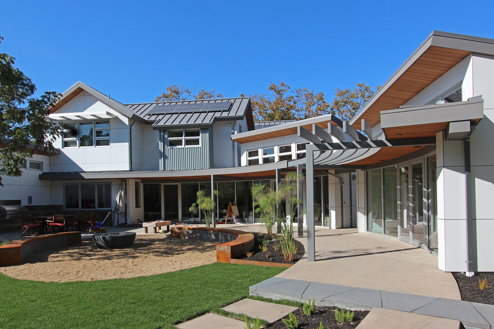 Immagine di un ampio patio o portico moderno dietro casa con un tetto a sbalzo