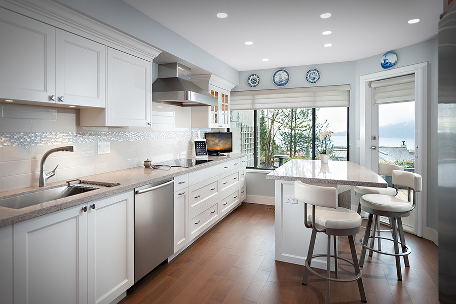 Inspiration for a mid-sized transitional galley dark wood floor kitchen remodel in Vancouver with white cabinets, granite countertops, white backsplash, stainless steel appliances and an island