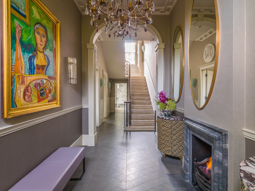 This is an example of a large traditional entry hall in London with multi-coloured walls and grey floor.
