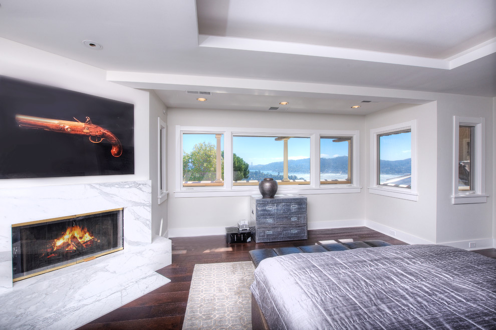 Large mediterranean master bedroom in San Francisco with white walls, dark hardwood floors, a standard fireplace and a stone fireplace surround.