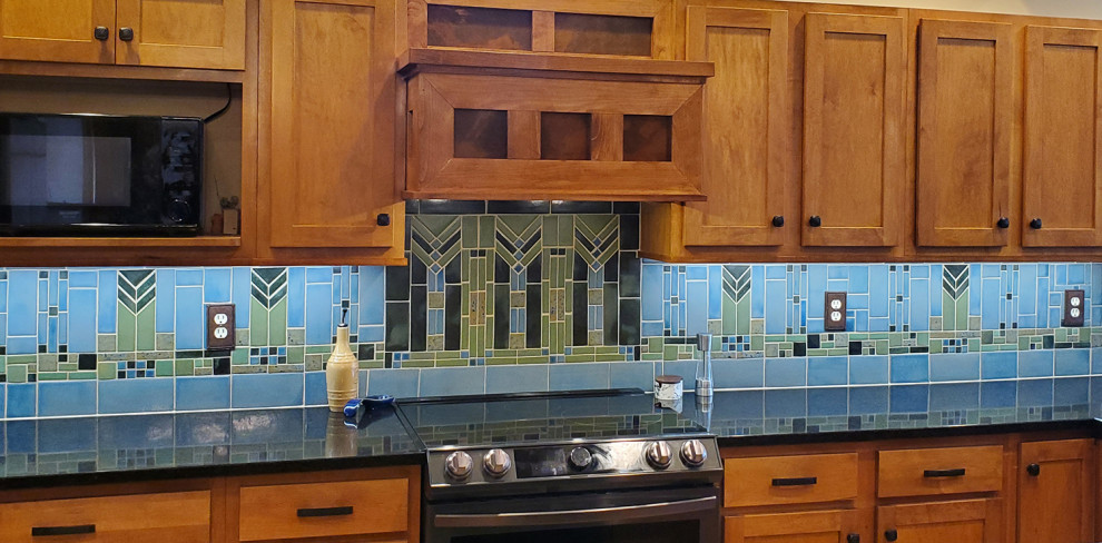 Foto di una grande cucina stile americano con ante in stile shaker, ante marroni, paraspruzzi blu, elettrodomestici neri, top nero, lavello da incasso e paraspruzzi con piastrelle in terracotta
