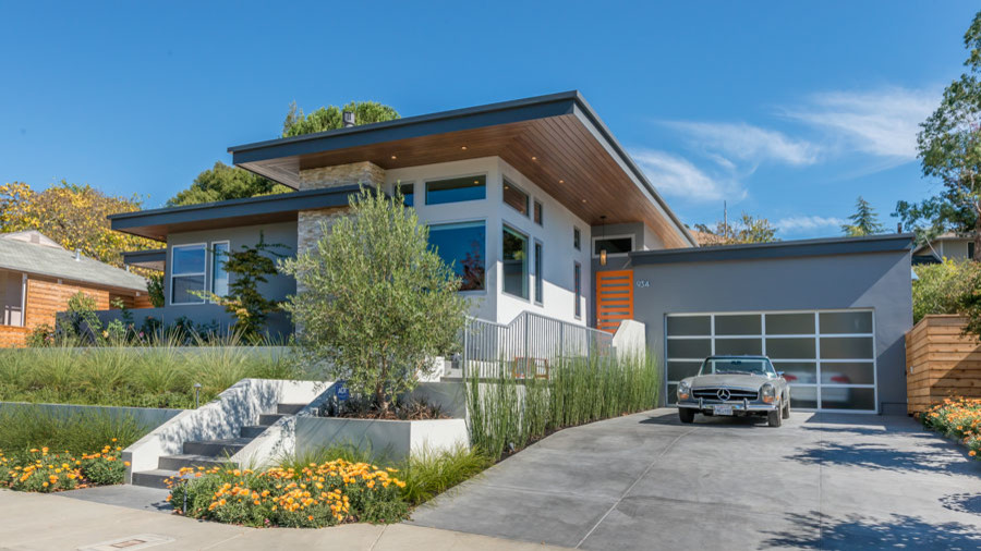 Photo of a large midcentury one-storey stucco grey house exterior in San Francisco with a flat roof.