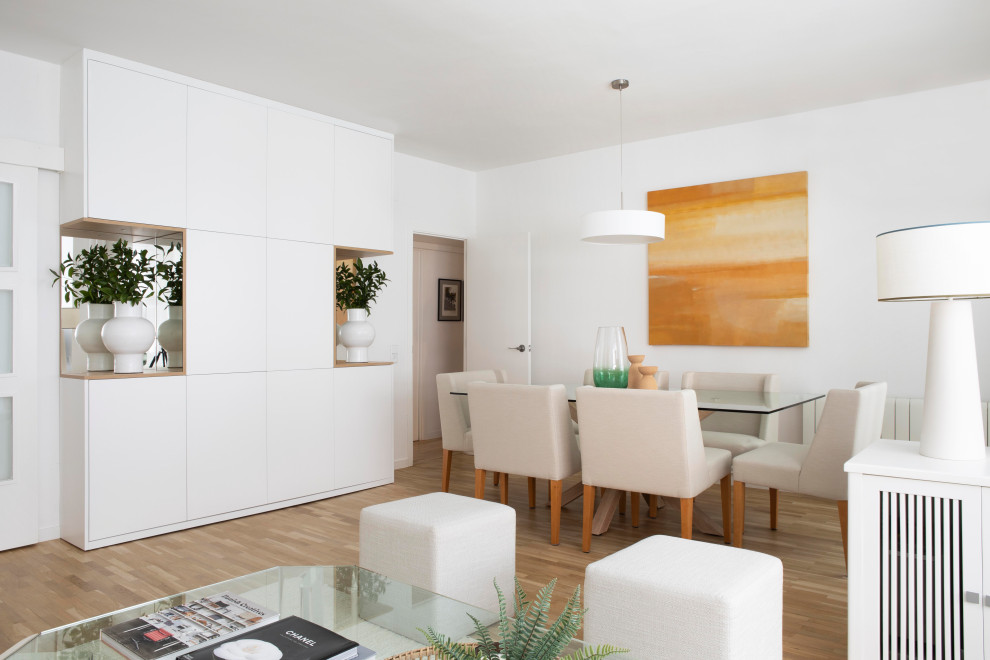 Contemporary open plan dining in Barcelona with white walls and light hardwood floors.