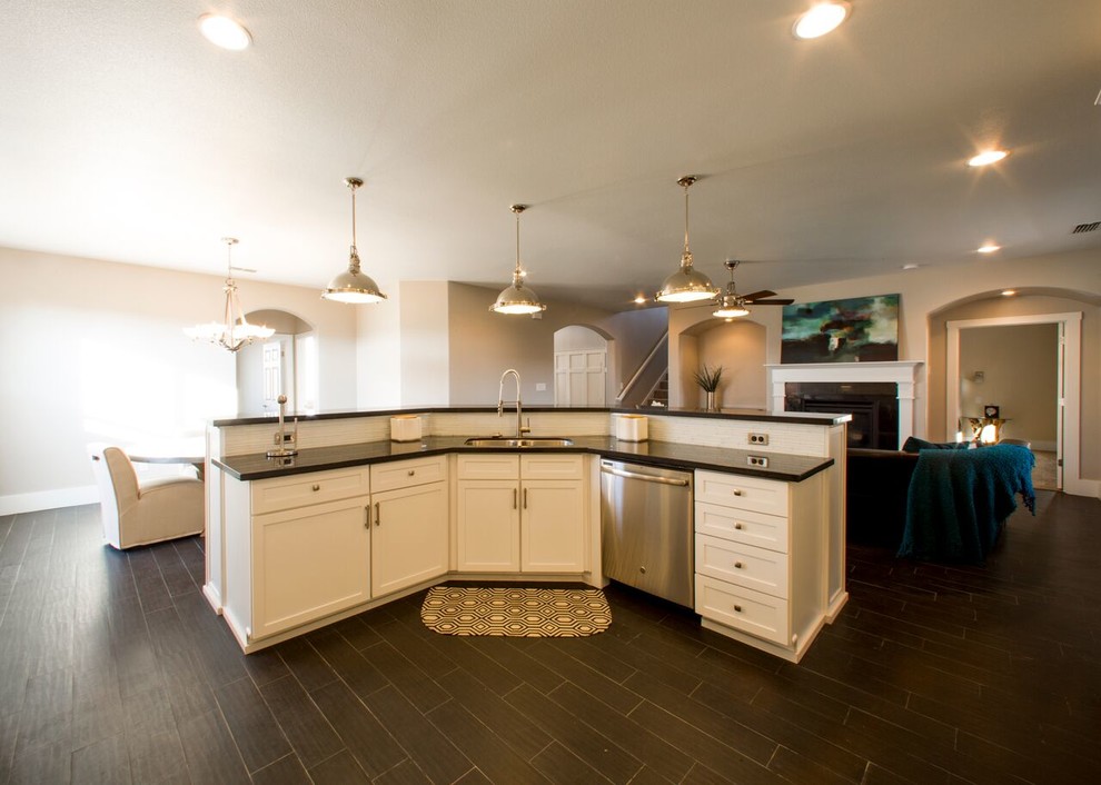 Inspiration for a transitional porcelain tile home design remodel in Austin with an undermount sink, shaker cabinets, white cabinets, granite countertops, white backsplash, glass sheet backsplash, stainless steel appliances and an island