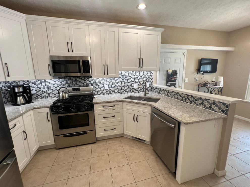 Photo of a mid-sized traditional u-shaped eat-in kitchen in Cleveland with shaker cabinets, white cabinets, quartz benchtops and mosaic tile splashback.