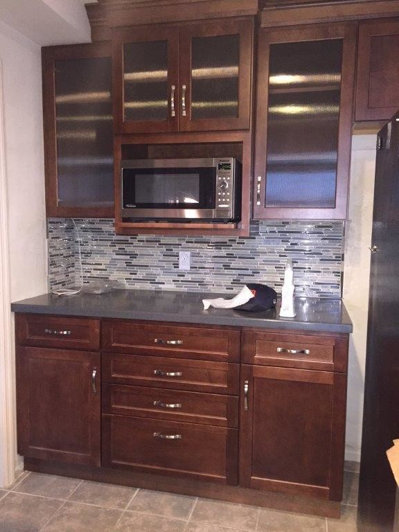 Mid-sized transitional l-shaped porcelain tile eat-in kitchen photo in Cincinnati with an undermount sink, shaker cabinets, granite countertops, multicolored backsplash, glass tile backsplash, stainless steel appliances, an island and dark wood cabinets