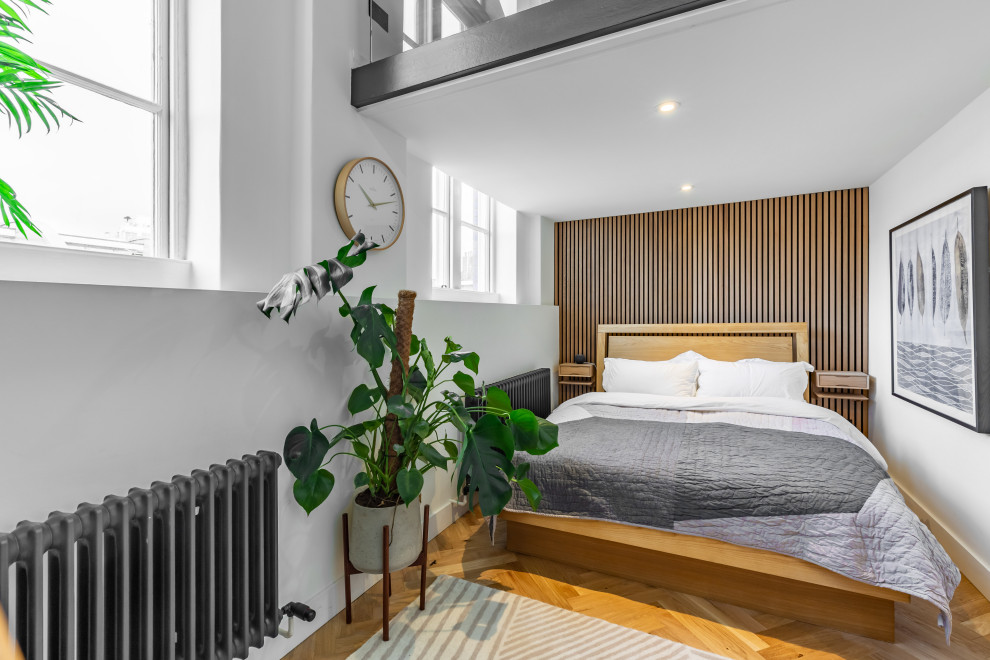 Свежая идея для дизайна: спальня в современном стиле с белыми стенами, паркетным полом среднего тона, коричневым полом и деревянными стенами - отличное фото интерьера
