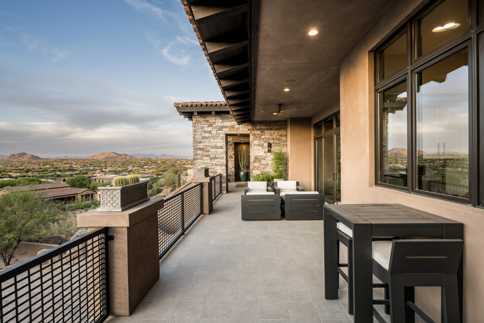 Inspiration for an expansive balcony in Phoenix with with privacy feature, a roof extension and metal railing.