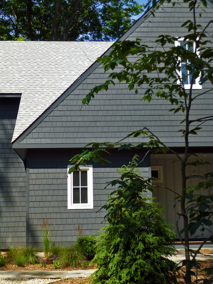This is an example of a scandinavian two-storey green exterior in Chicago with concrete fiberboard siding and a gable roof.