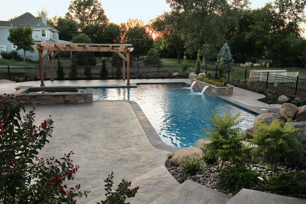 Design ideas for a large contemporary backyard l-shaped natural pool in Kansas City with a hot tub and stamped concrete.