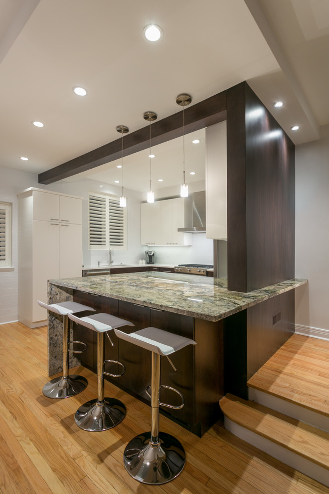 Photo of a mid-sized contemporary galley separate kitchen in Chicago with an undermount sink, flat-panel cabinets, beige cabinets, quartz benchtops, white splashback, cement tile splashback, stainless steel appliances, medium hardwood floors and with island.