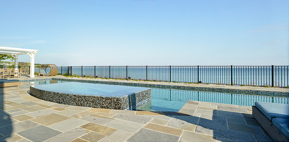Example of a large transitional backyard stone and custom-shaped natural hot tub design